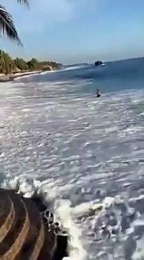 A surfer ravaged by a big wave on the beach